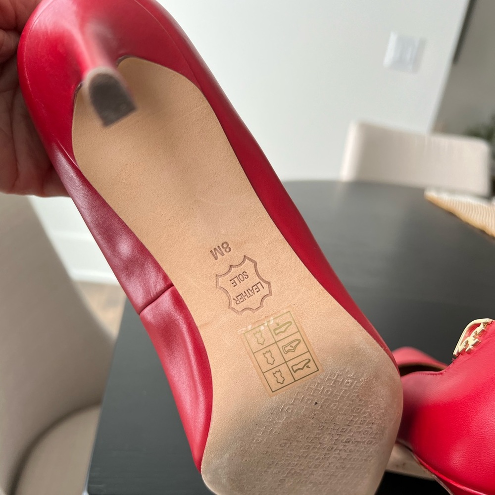 Pristine condition pre-owned Tory Burch red pumps with gold signature logo.